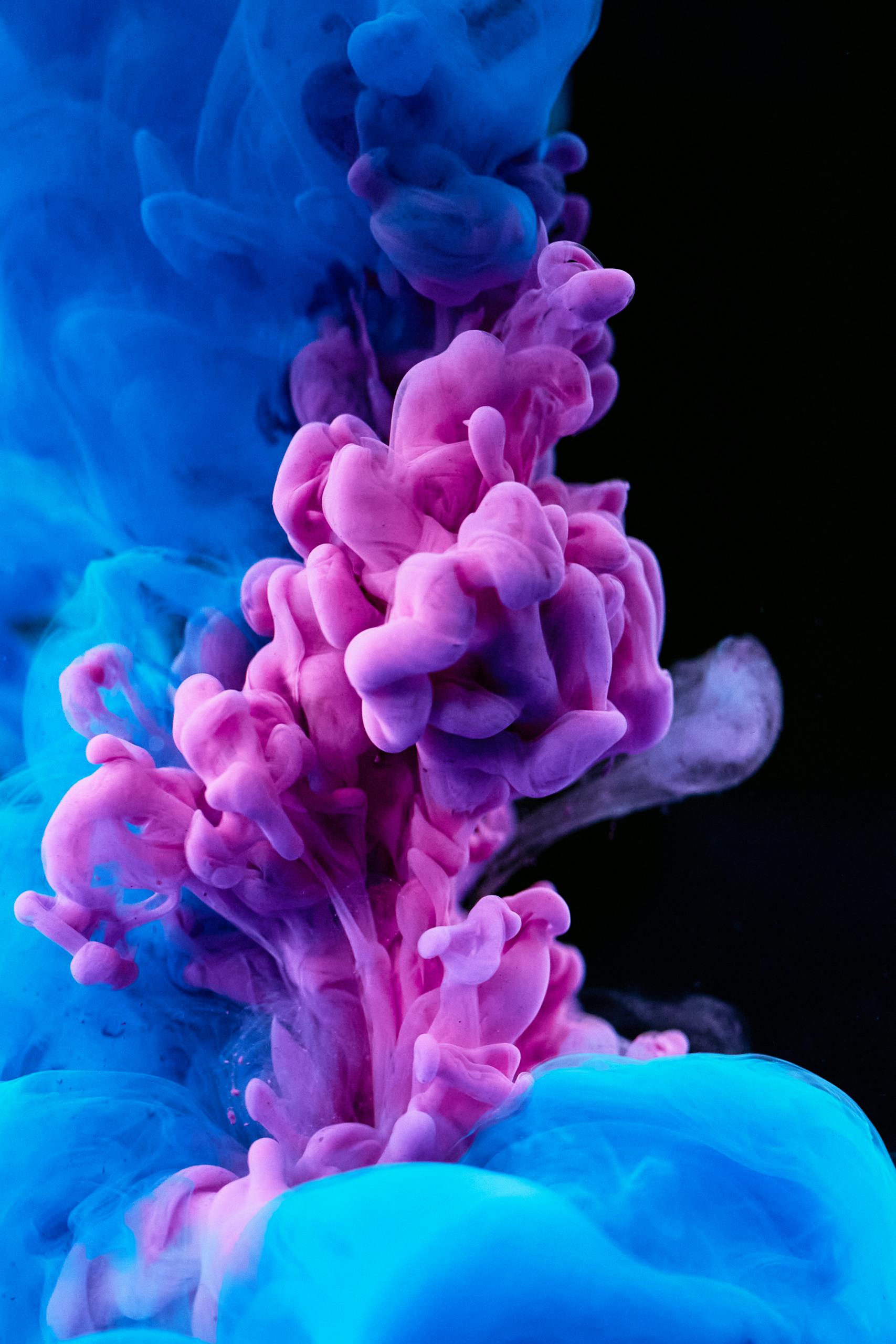 Stunning capture of colorful ink diffusing in water, showcasing vibrant blues and purples.